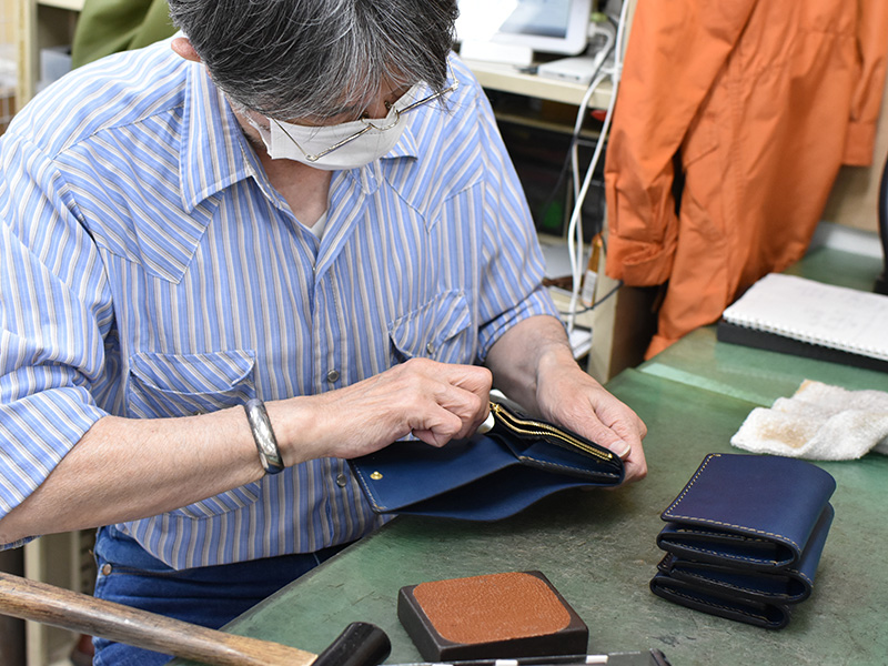 ネイビー革の小型の二つ折り財布(WS-64)を制作する様子